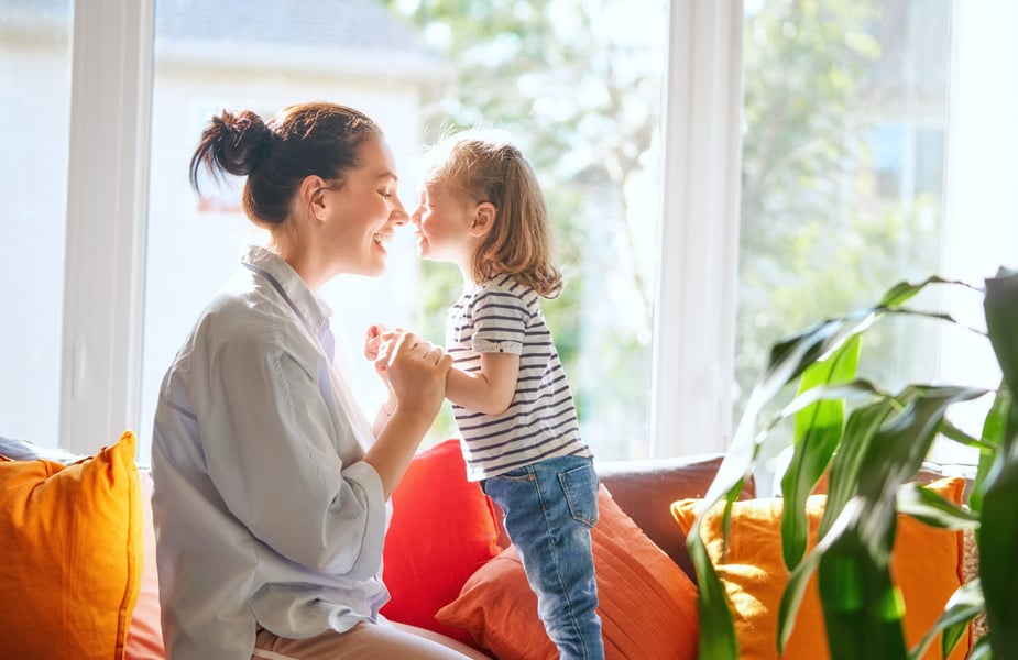 En mamma och en dotter sitter i en soffa