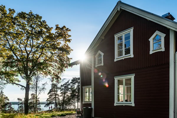 Rött hus med sol och träd